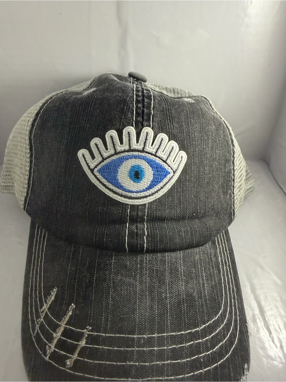 Distressed Black Trucker Hat with Blue Eye Patch